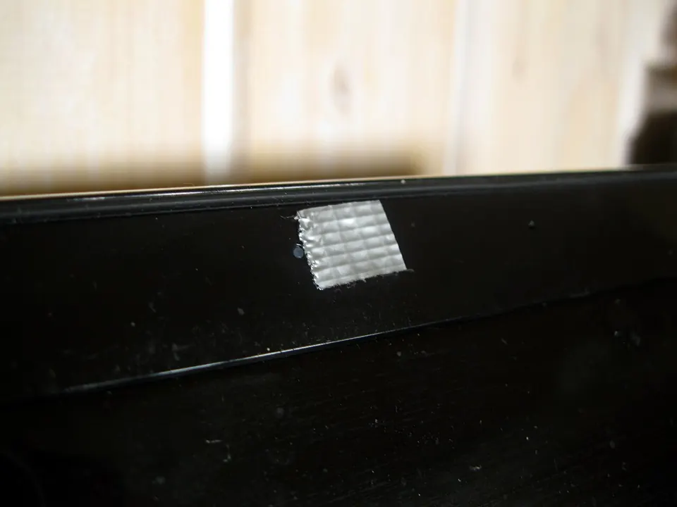 A strip of tape covering the webcam above a laptop screen